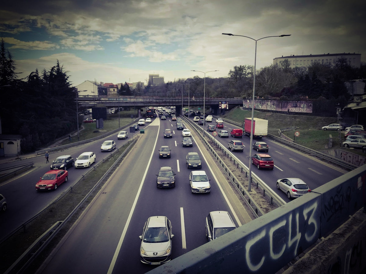 different vehicles on road under blue and white skies