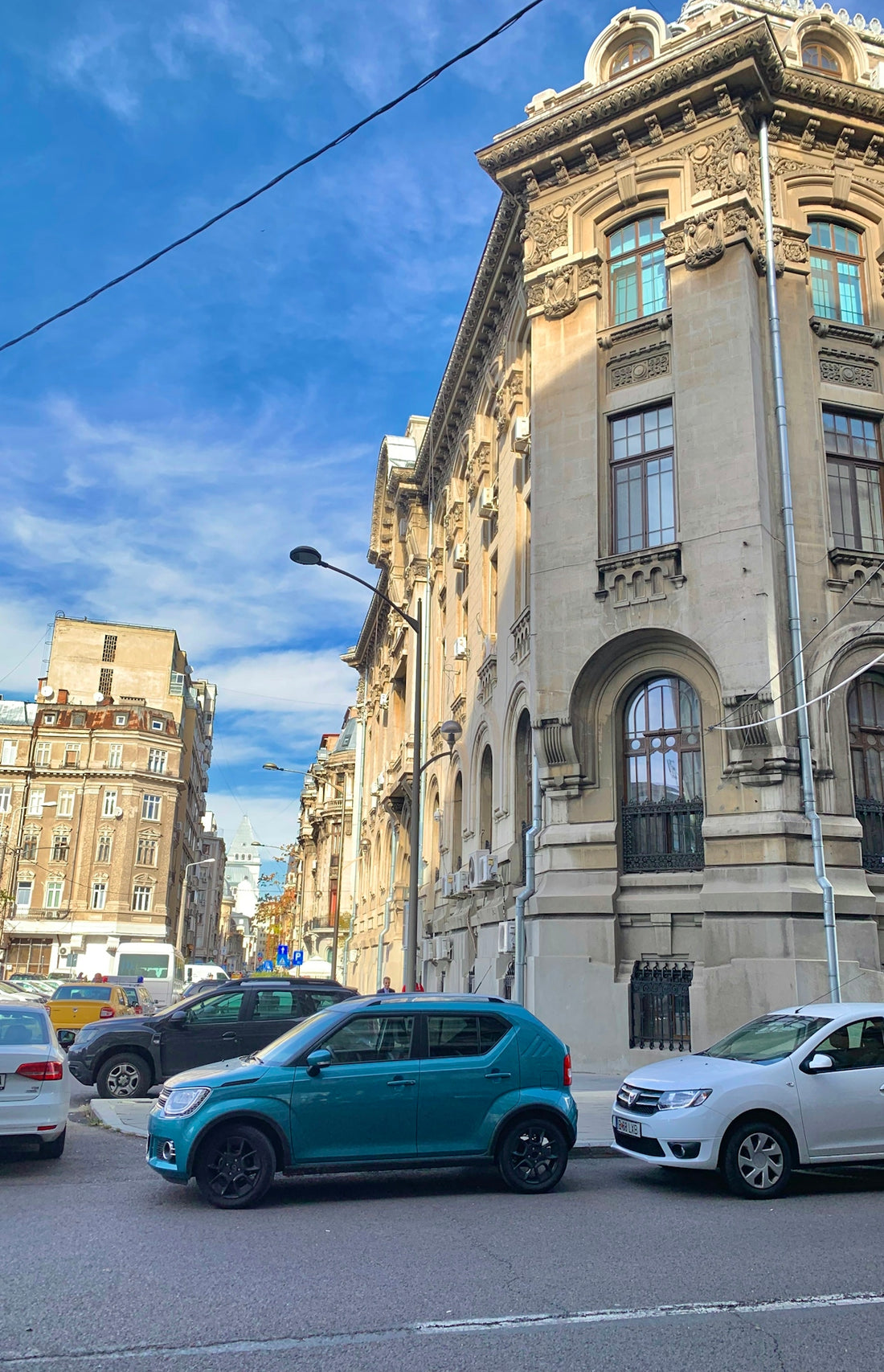 cars parked beside brown concrete building during daytime