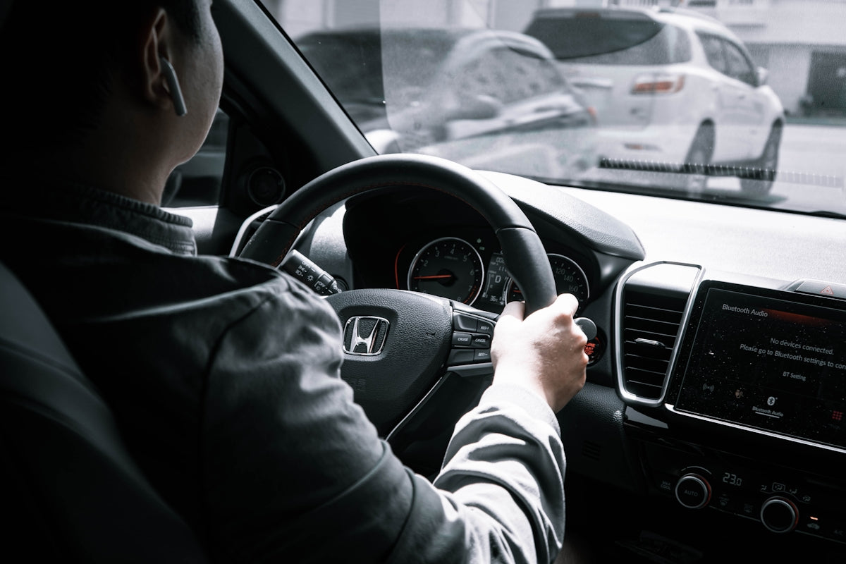 man in gray long sleeve shirt driving car