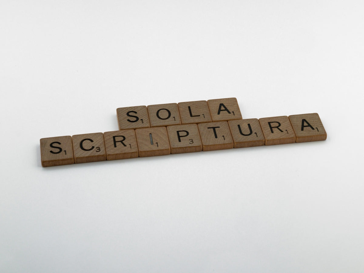 scrabble tiles spelling the word sola scriptura on a white background