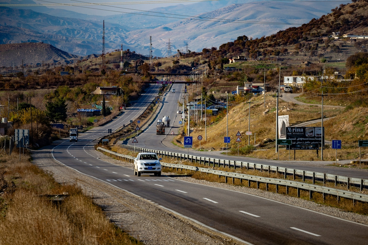 a white van driving down a curvy road