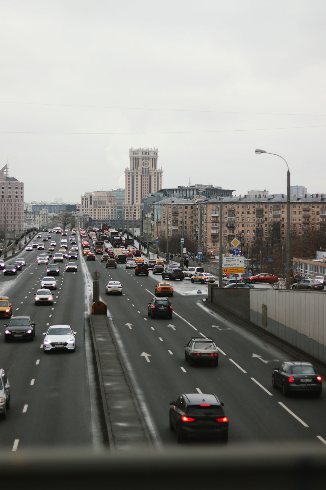 a highway filled with lots of traffic next to tall buildings