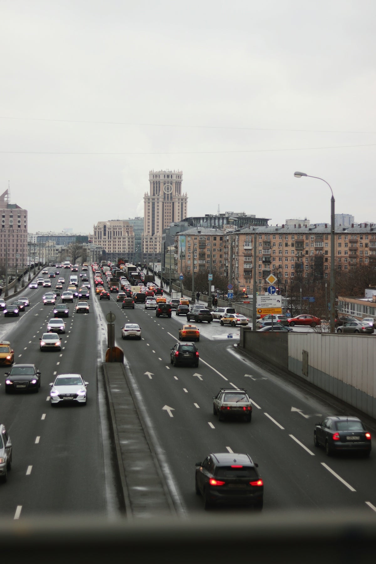 a highway filled with lots of traffic next to tall buildings