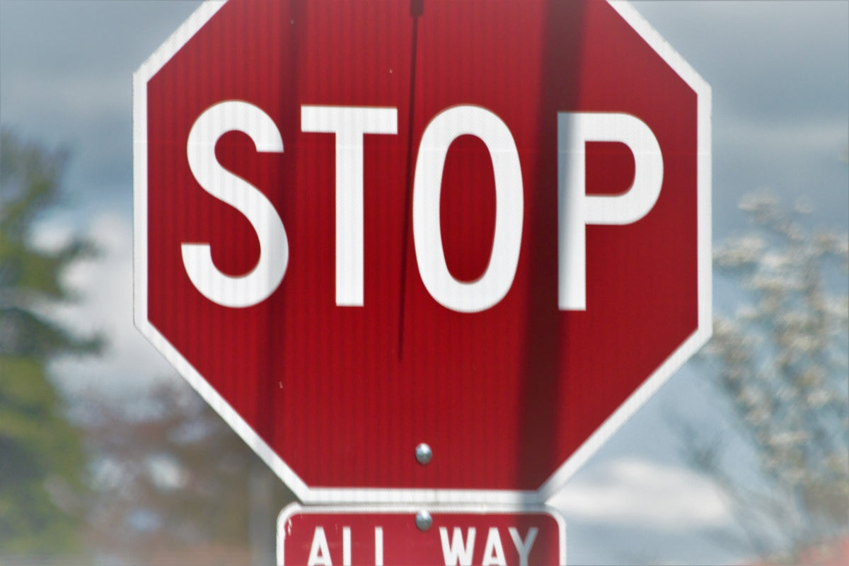 a red stop sign sitting on the side of a road