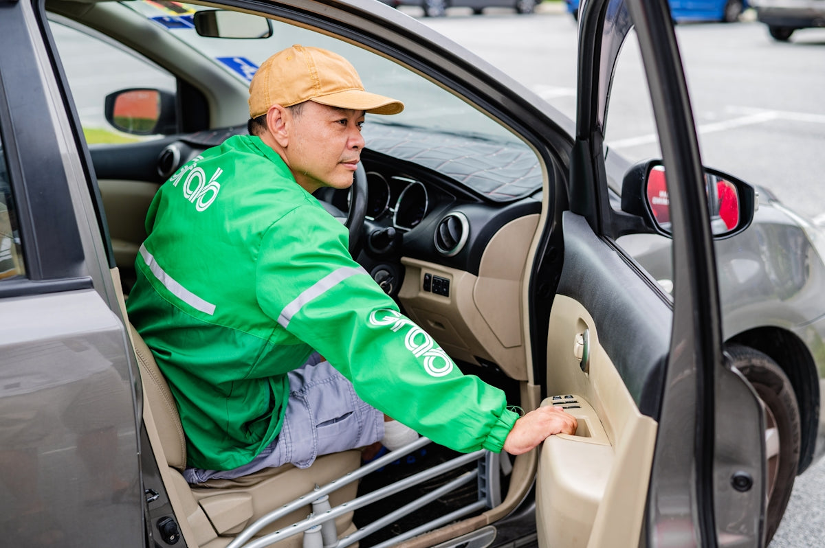 a man in a green jacket sitting in a car