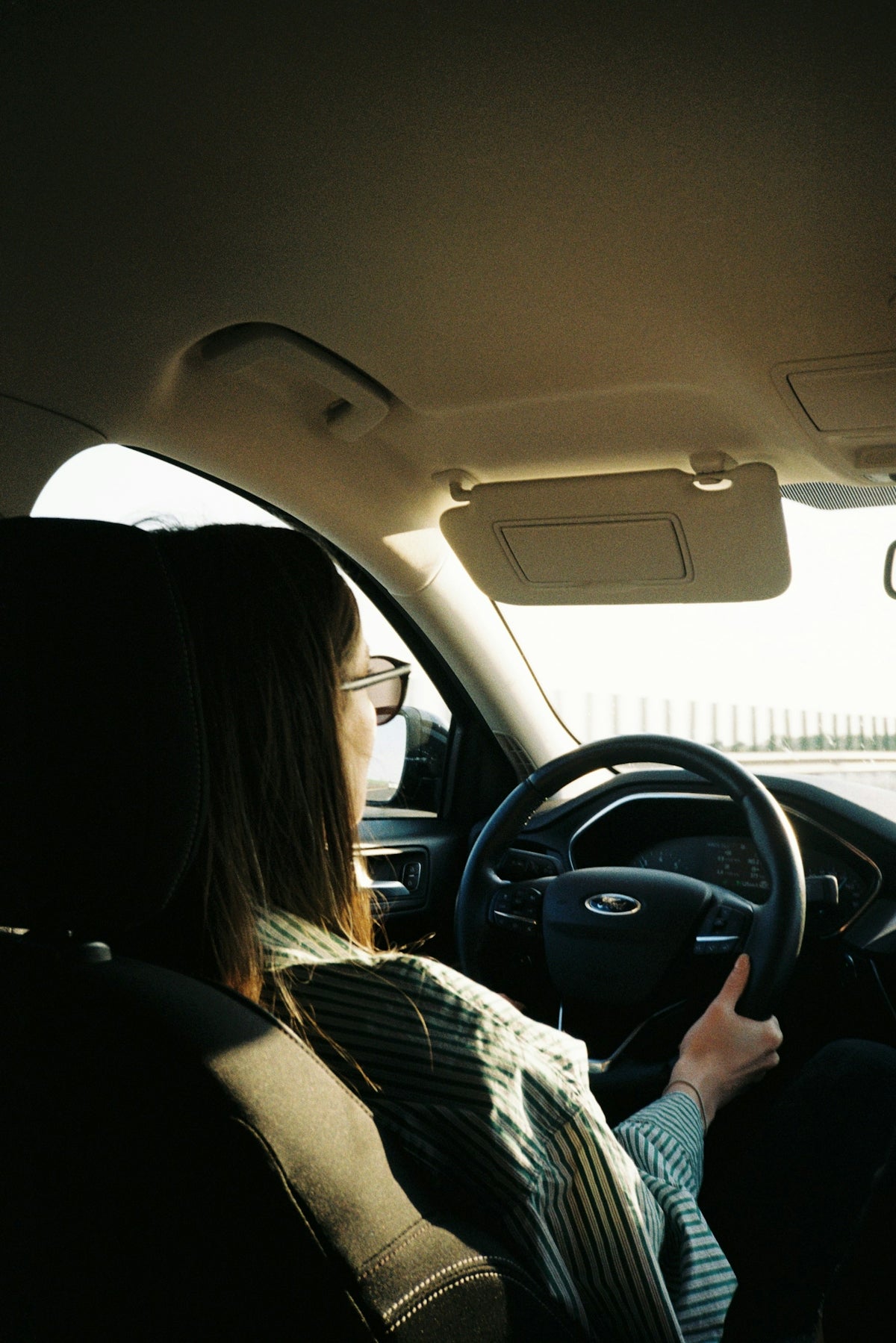 a woman driving a car on a sunny day