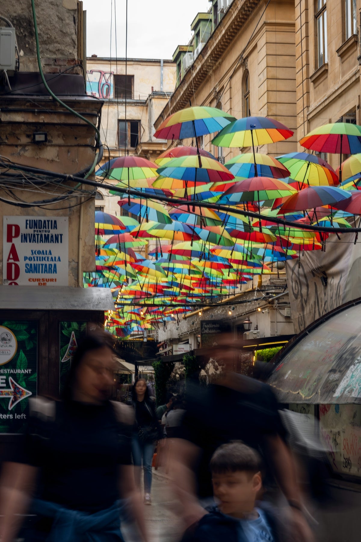 A group of people walking down a street under umbrellas