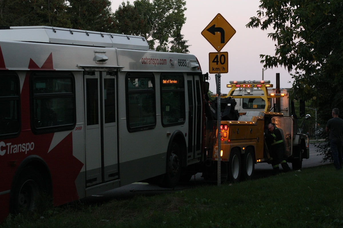 A tow truck towing a bus down a street