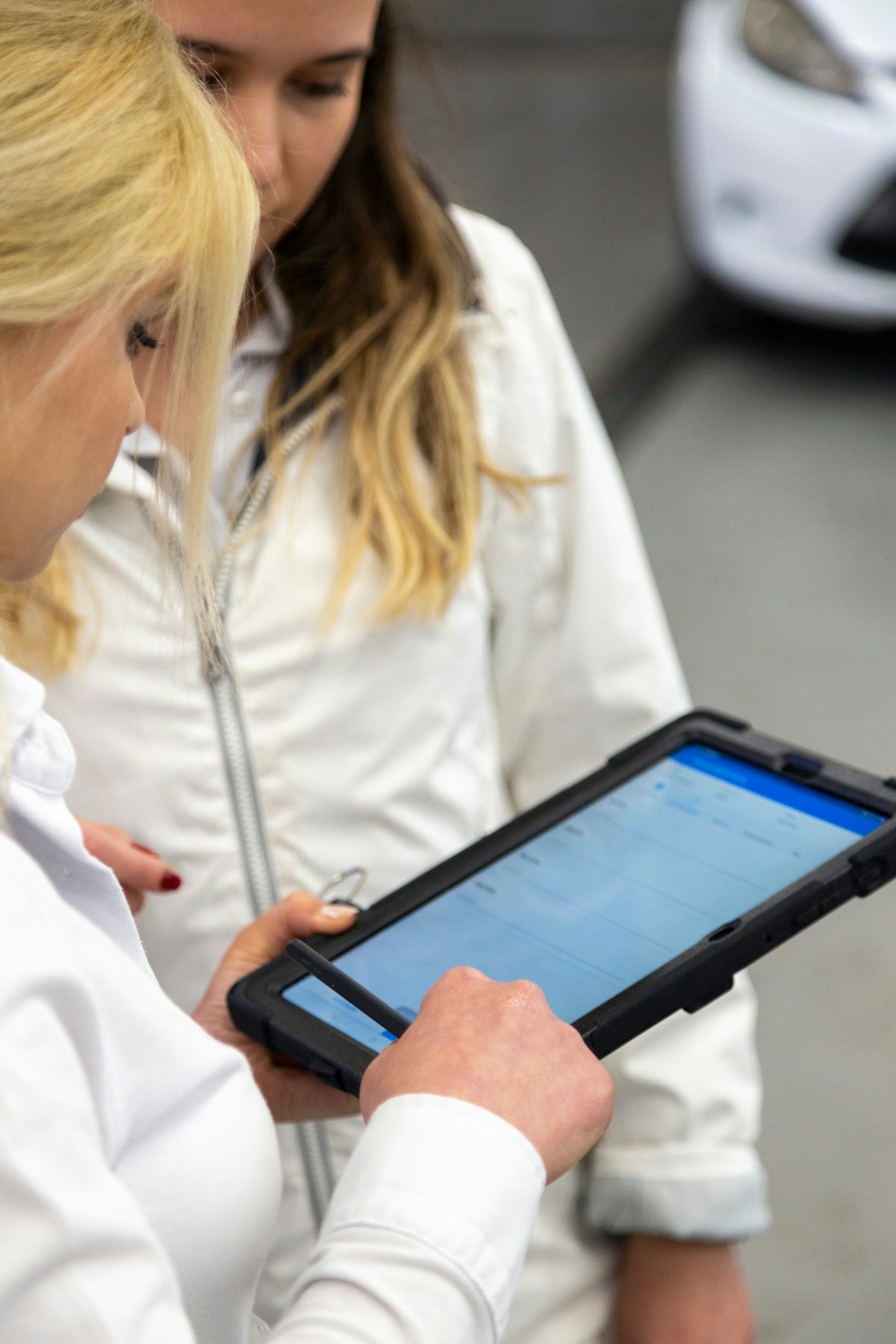 Two women are looking at a tablet screen