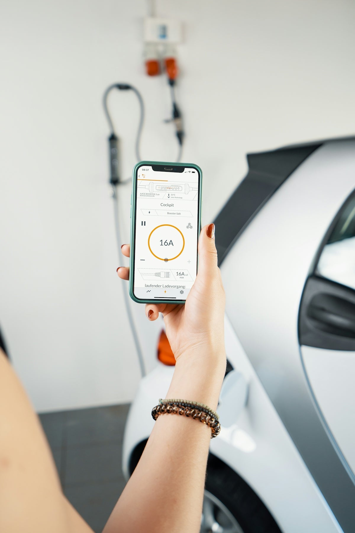 A woman holding a smart phone in front of a car