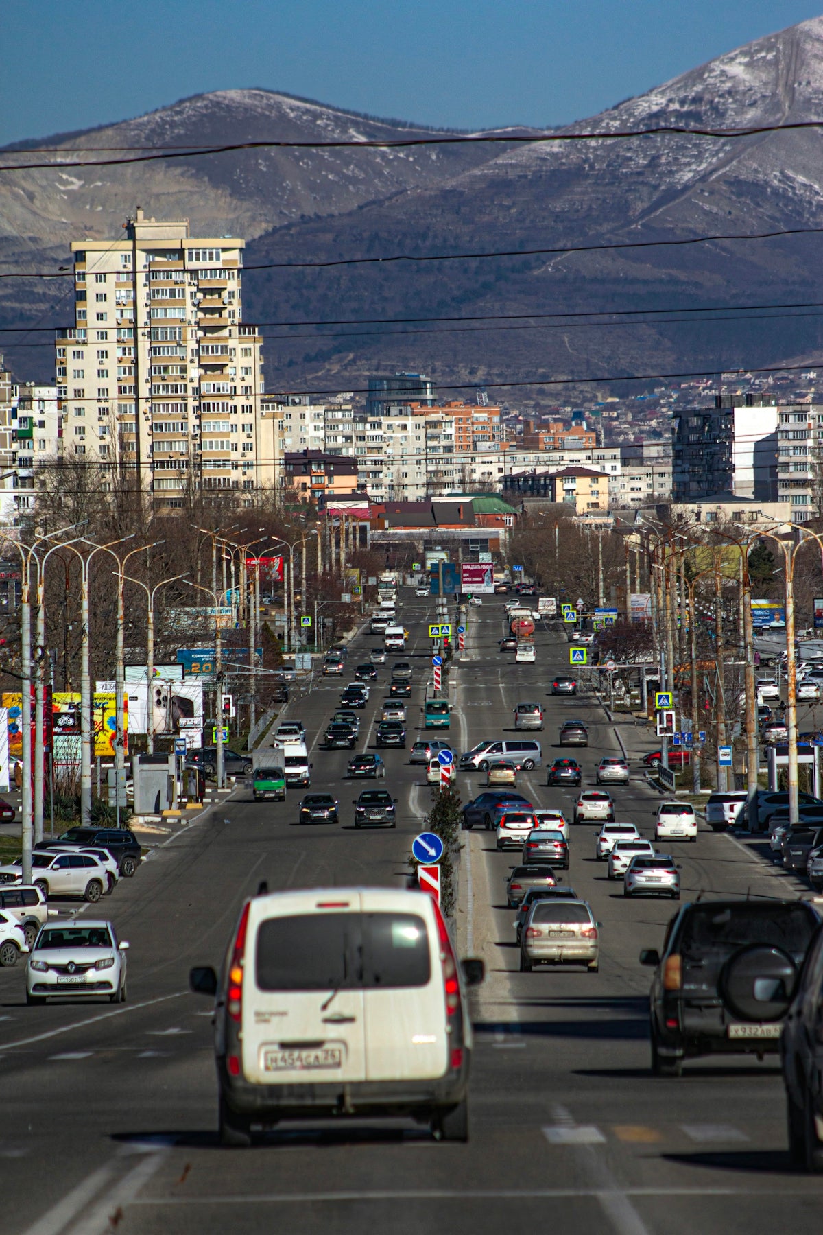 A city street filled with lots of traffic next to tall buildings