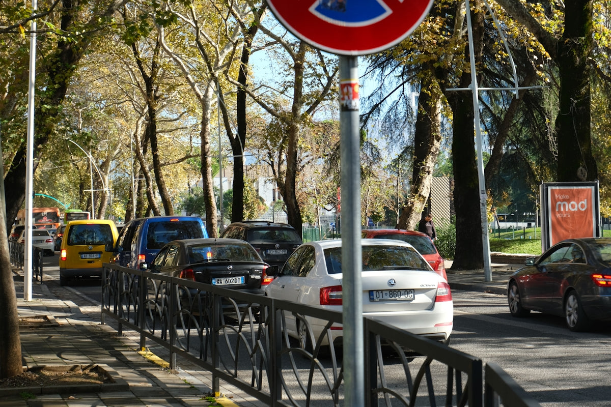 A red and blue street sign sitting on the side of a road