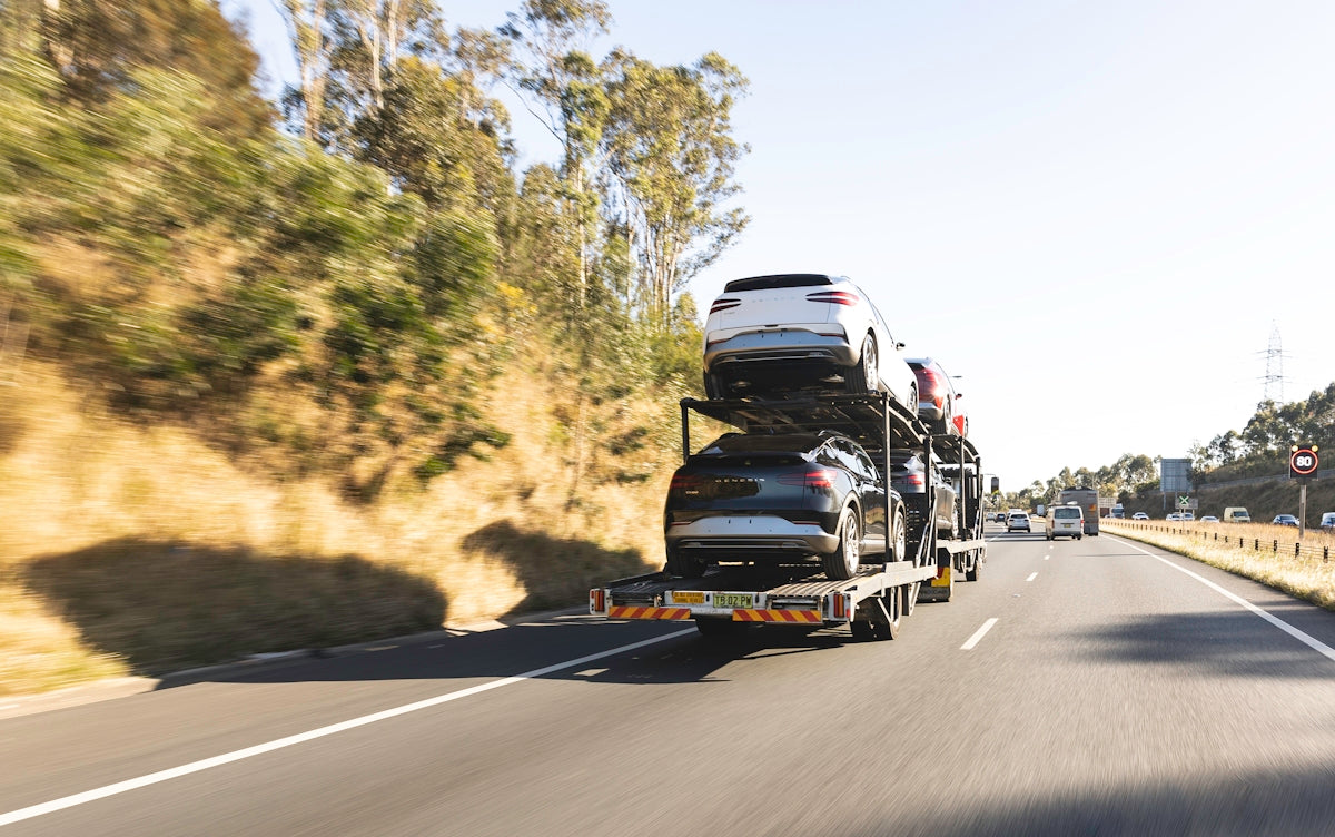 A car transporter truck drives along the highway.