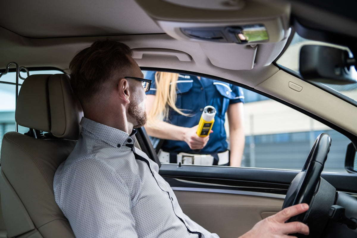 A police officer is performing a breathalyzer test.