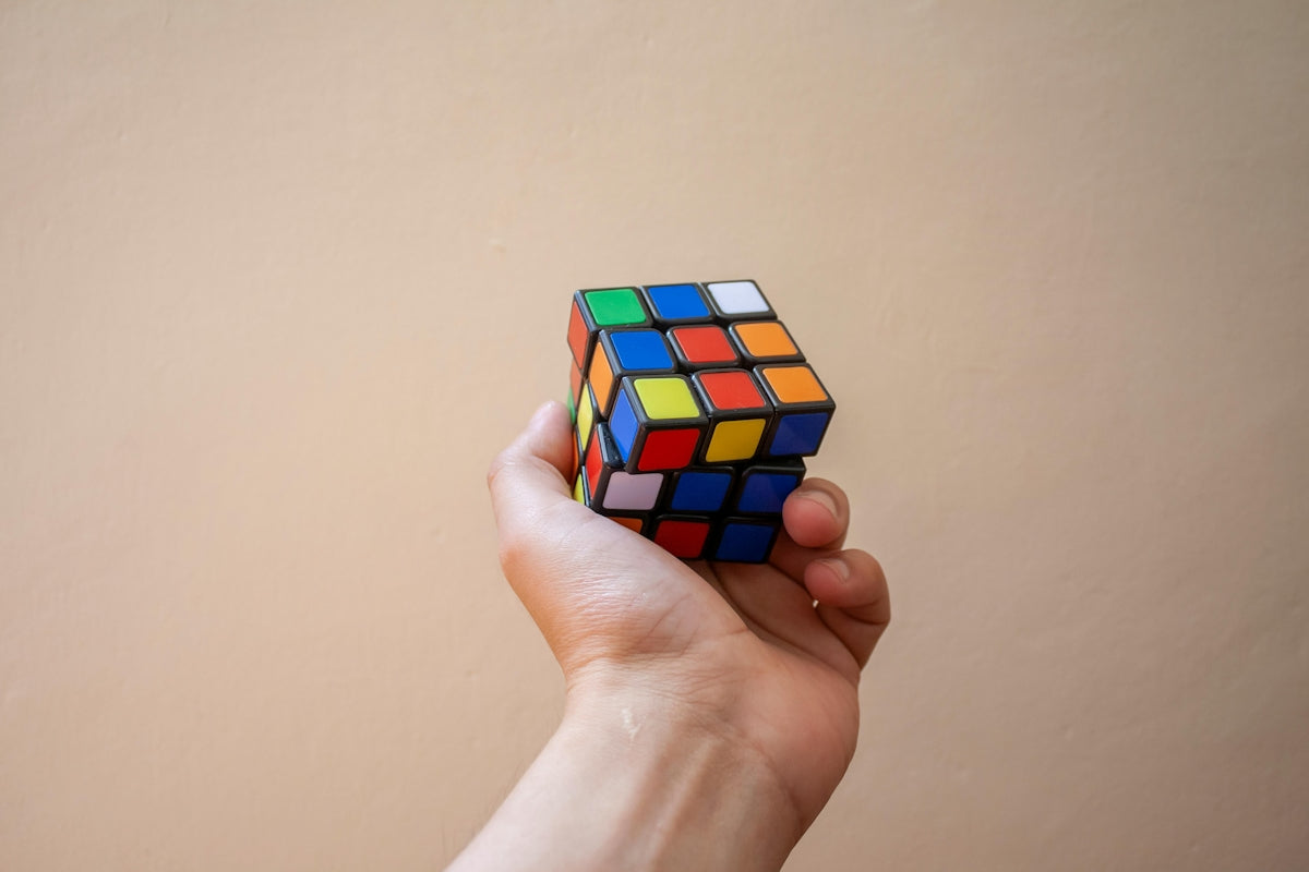 Hand holding a partially solved rubik's cube.