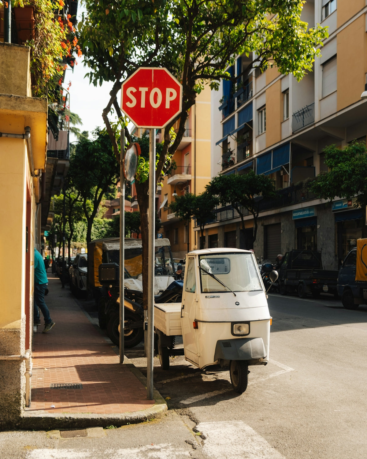 A stop sign and small truck on a city street.