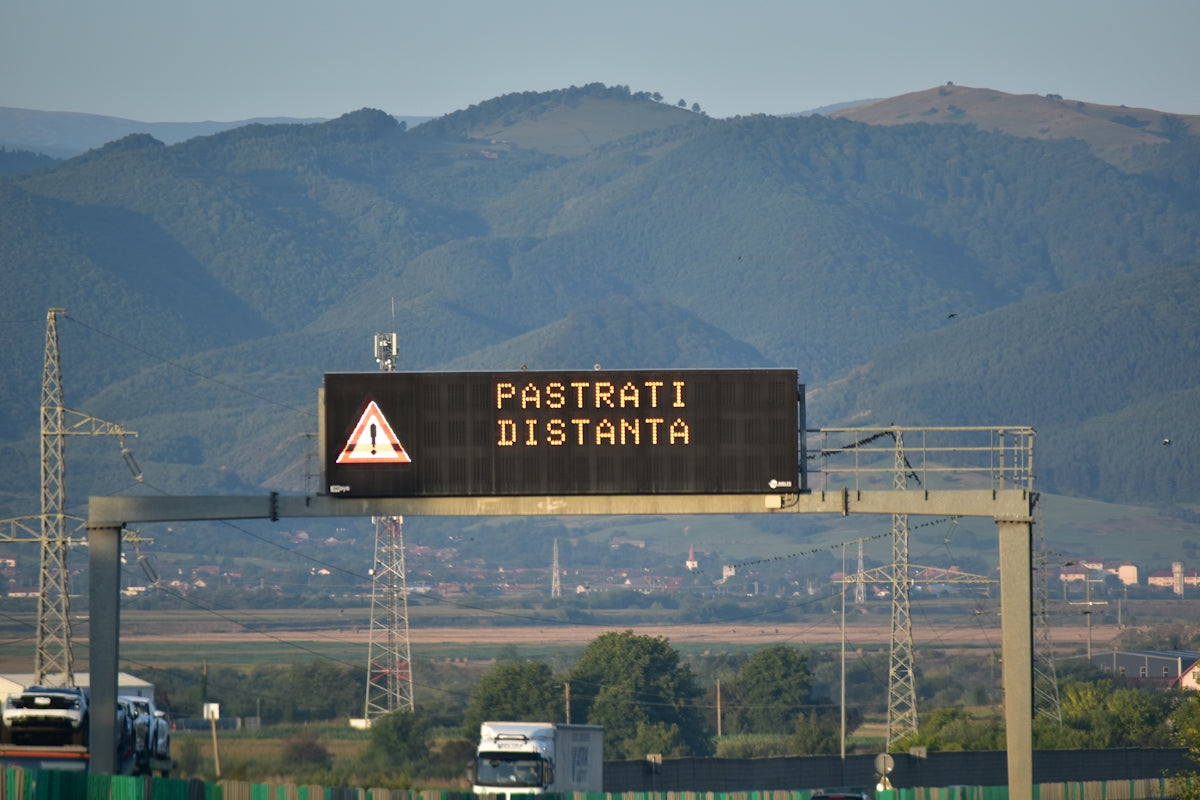 Digital road sign displays 'keep distance' with warning symbol