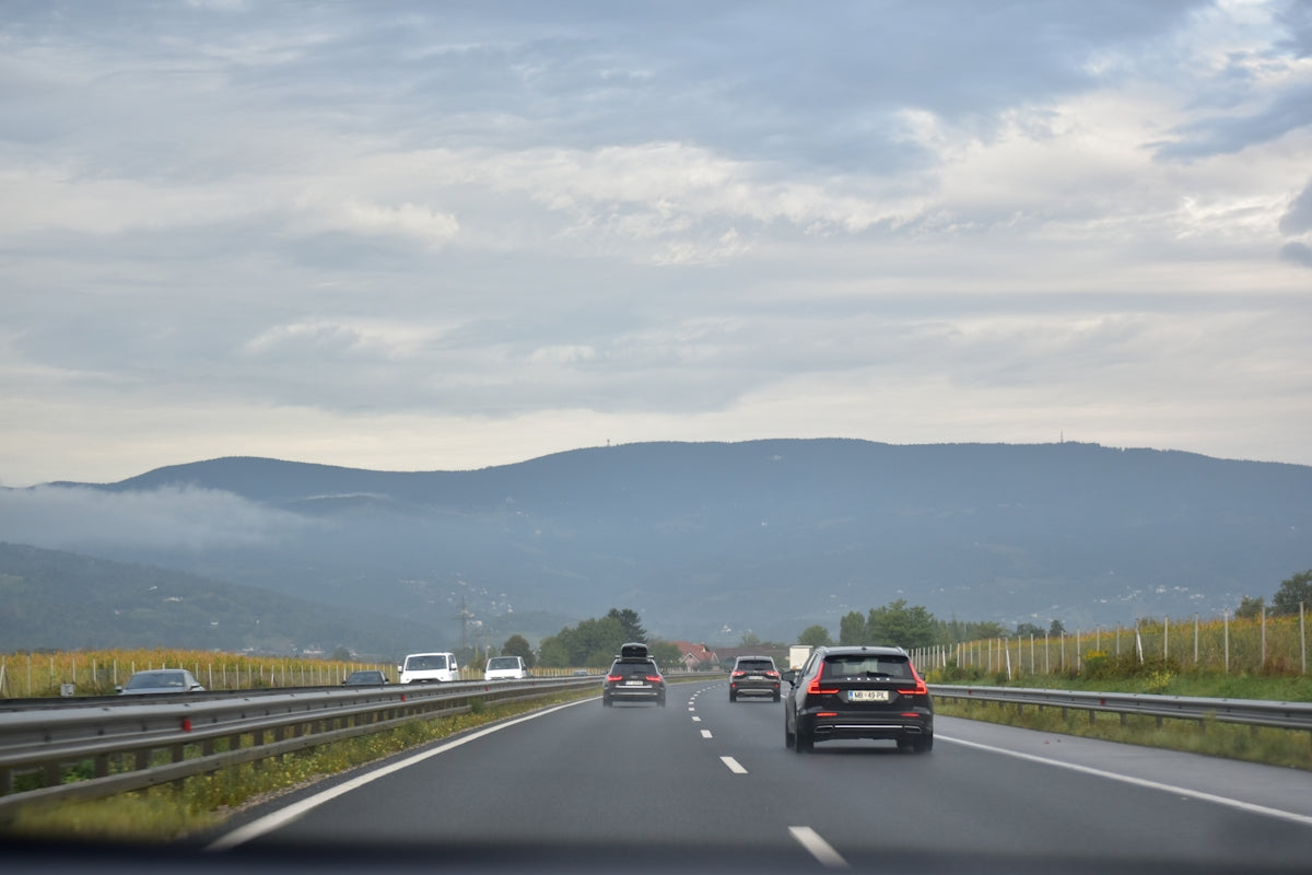 Cars driving on a highway with mountains in background