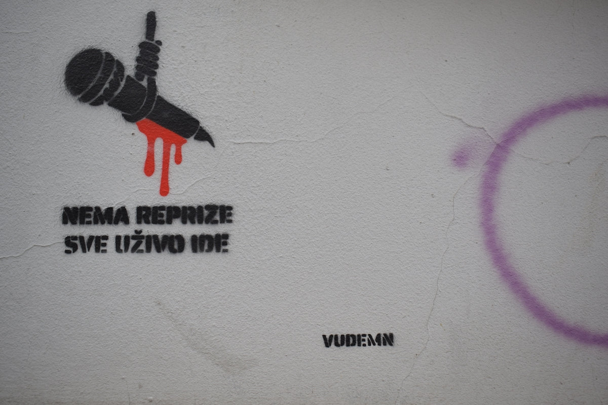 Graffiti of a microphone with dripping red paint.