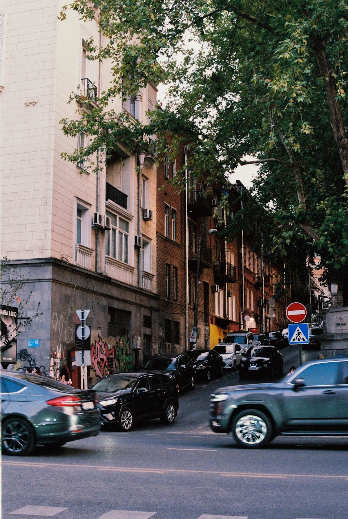 Cars on a street with buildings and trees.