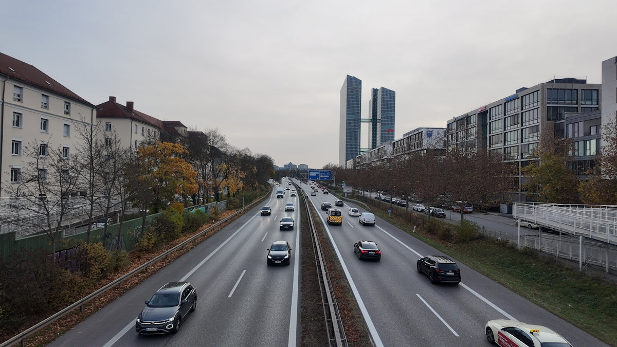 Cars driving on a highway with buildings in background