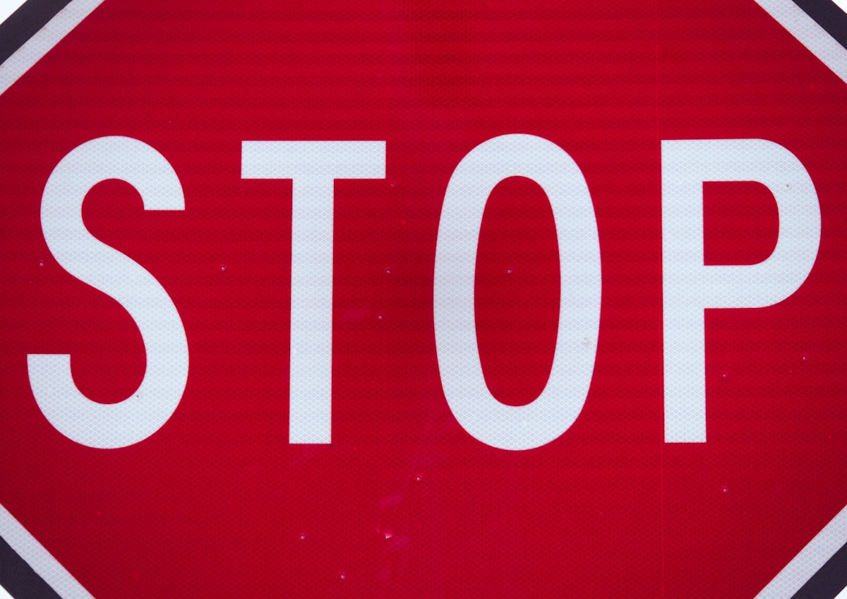 Red stop sign with white lettering