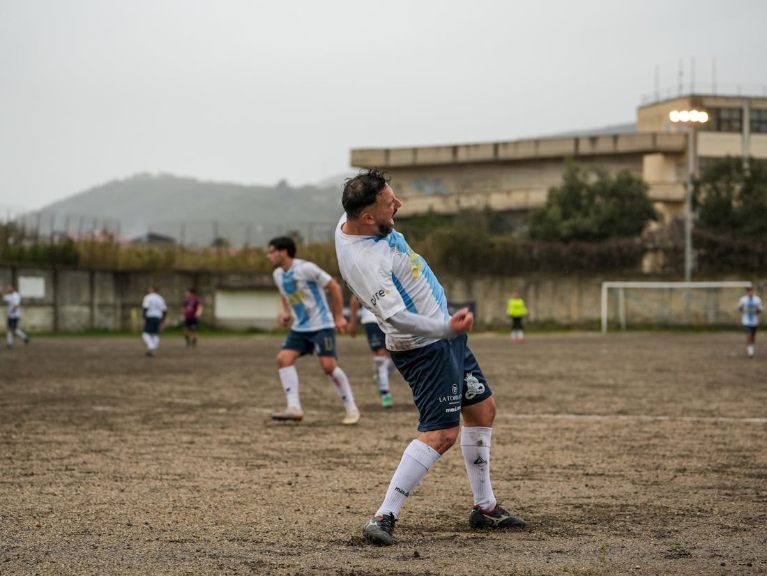 Soccer player celebrating a goal on a muddy field