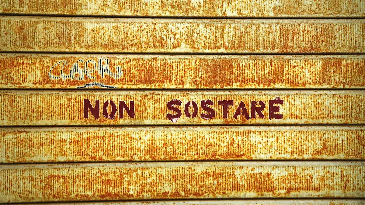 Rusty metal door with non sostare text.