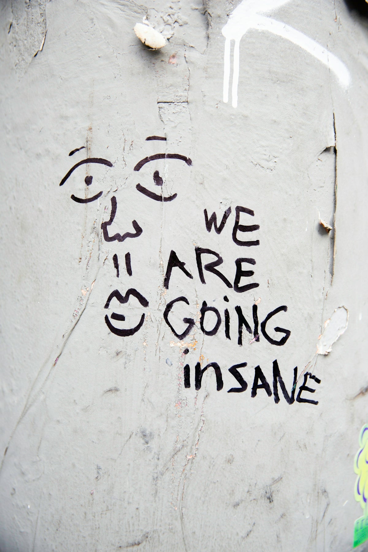 Graffiti of a face with text we are going insane