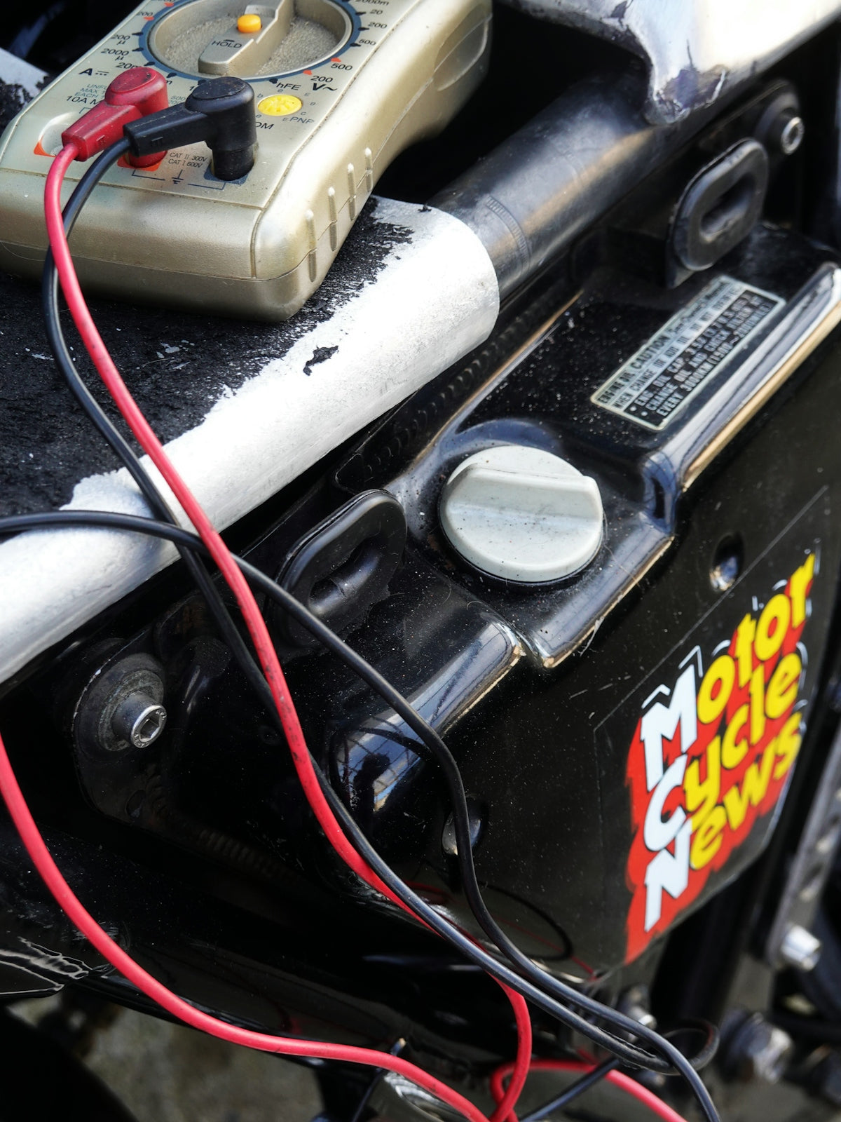 Multimeter connected to motorcycle battery