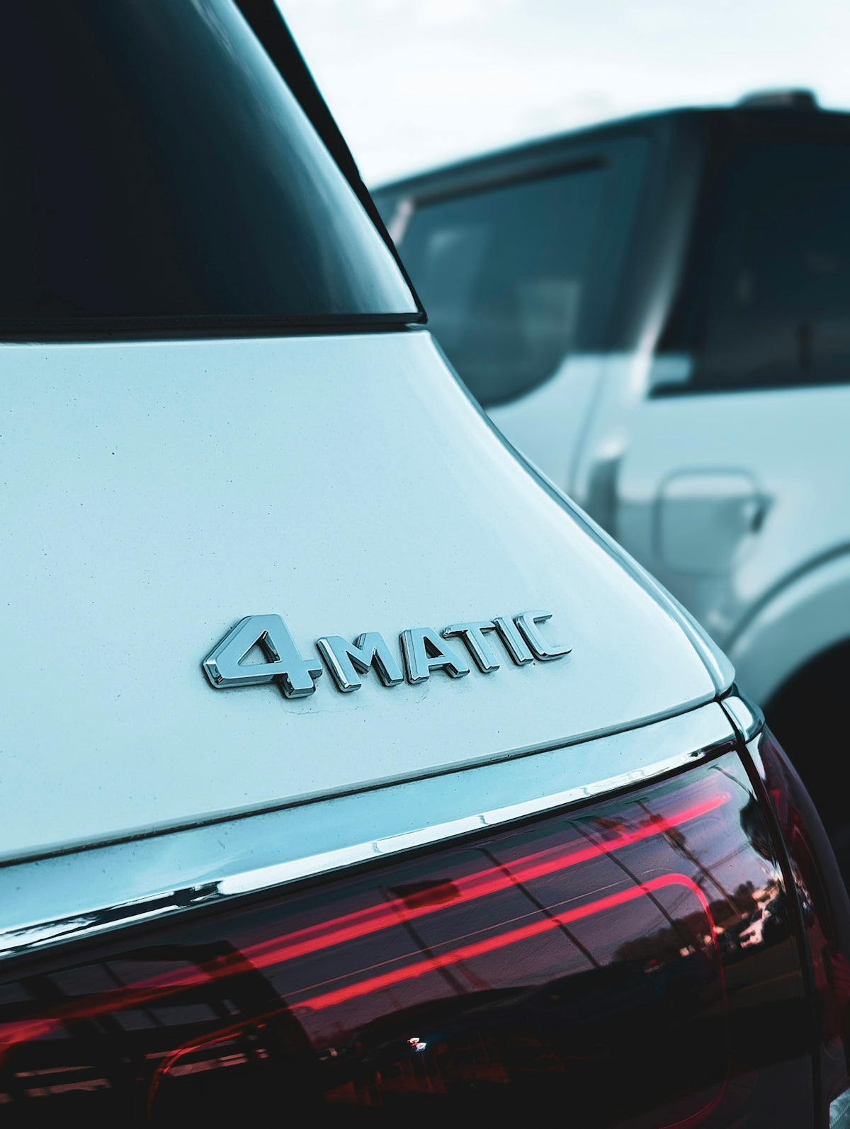 Close-up of a white car's 4matic emblem.