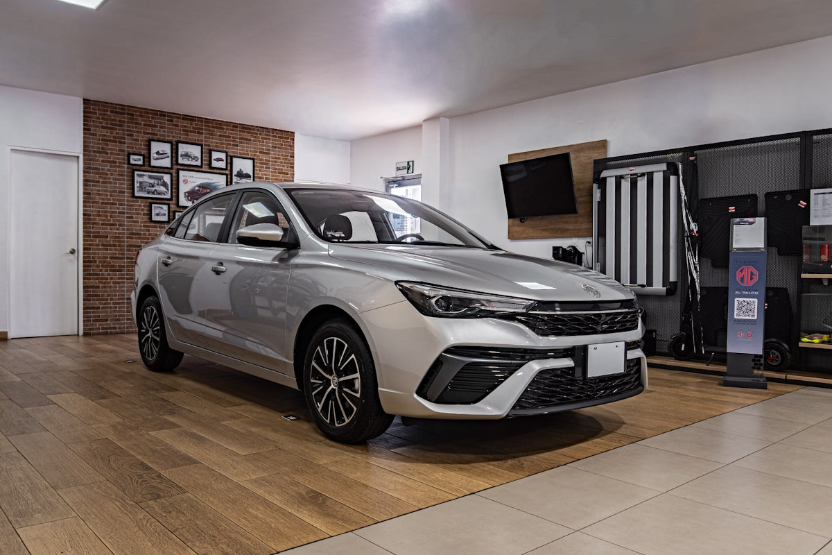 Silver sedan parked inside a modern showroom.