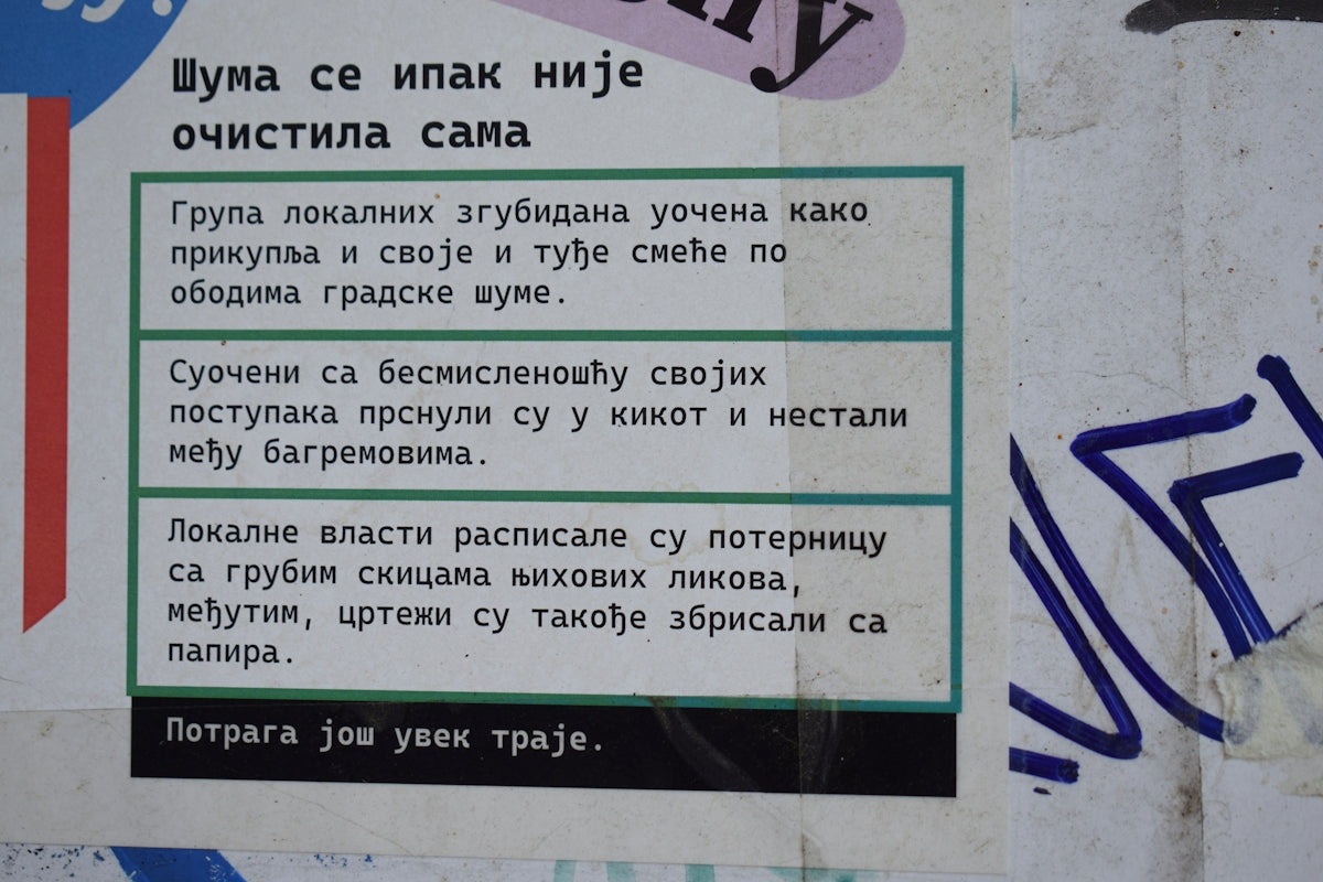 Text on a weathered wall with blue and white stripes.