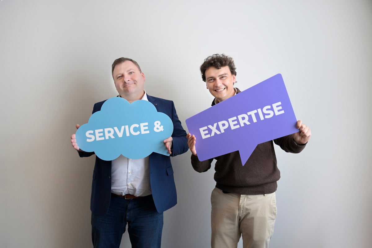 Two smiling men holding service & and expertise signs.