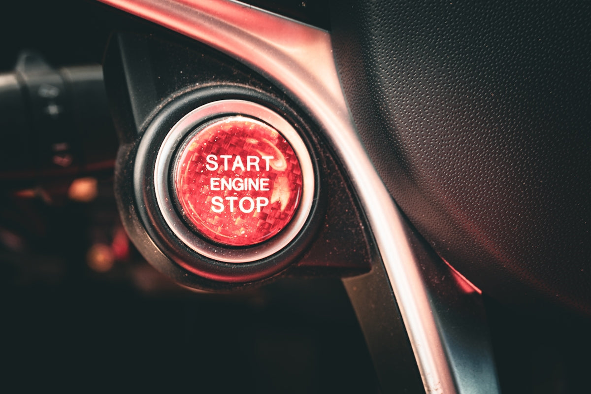 Red start engine stop button on a car dashboard.